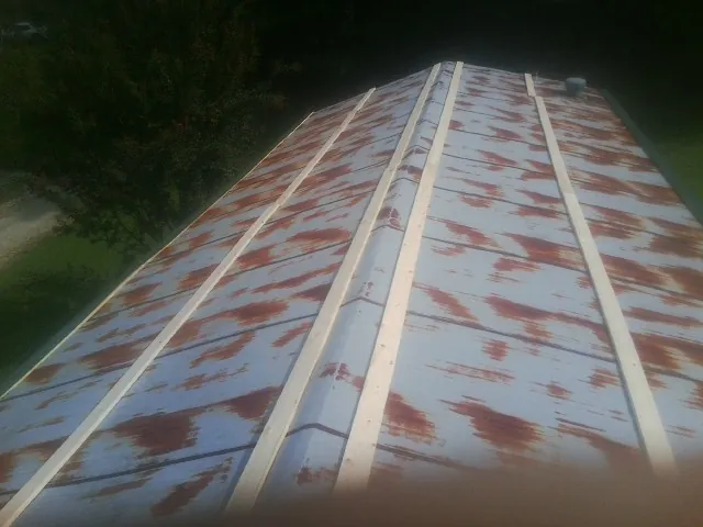 Rusted metal roof panels with new wood purlins before replacement — Storm Damage Roof Repair in Commodore by Roofing Brothers